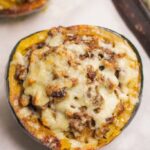 Beef Stuffed Acorn Squash on a parchment lined baking sheet.
