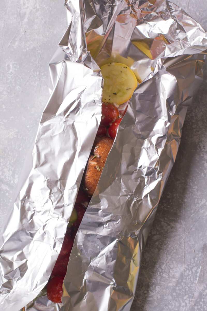 Aluminum foil tucked around veggies before being grilled.