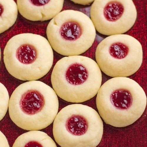 A close up image of Thumbprint Cookies on a bright red plate