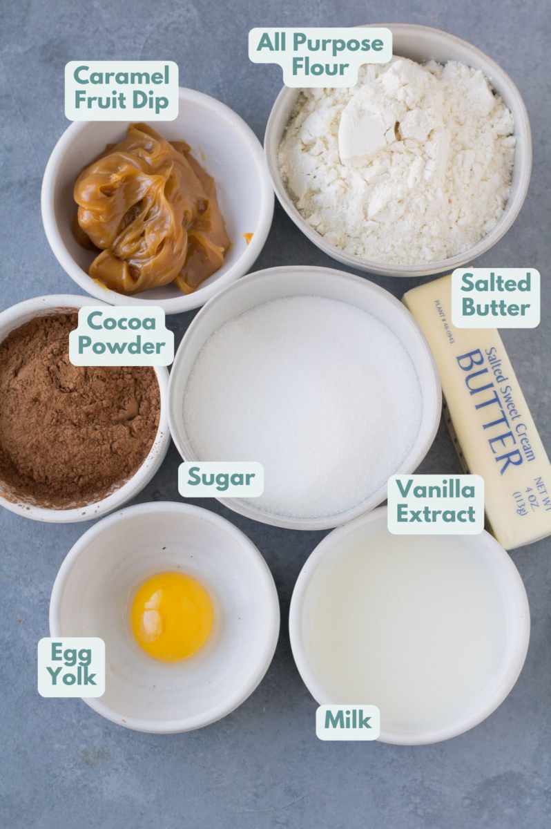 Ingredients for Chocolate Caramel Thumbprint Cookies in small white bowls on a grey background
