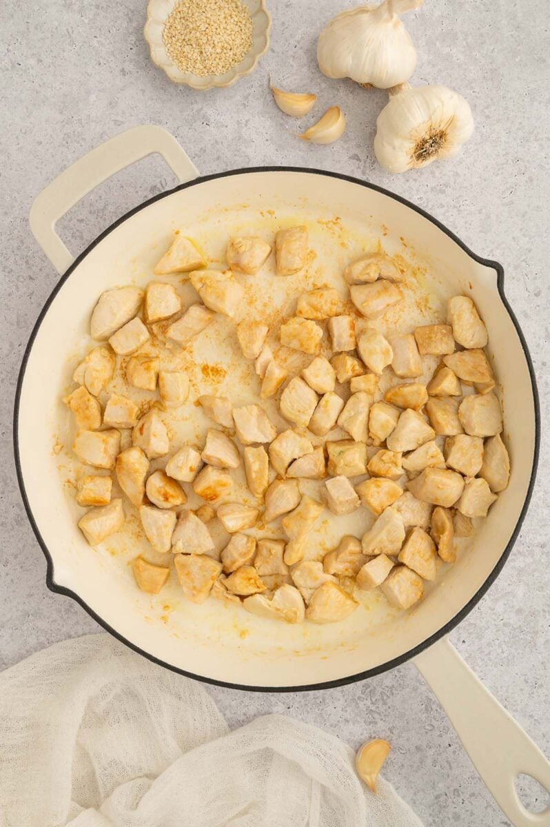 Chicken browning in a pan for sweet and sour chicken.