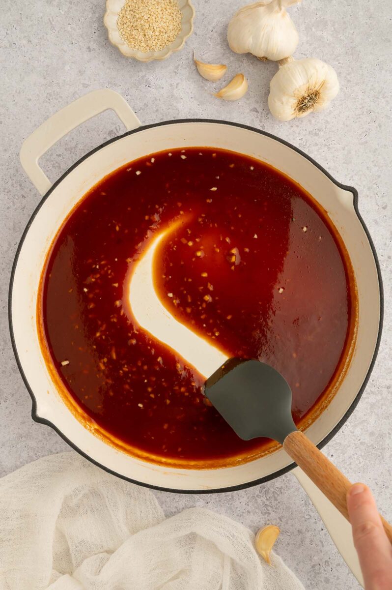 Healthy sweet and sour sauce in a pan after being cooked - nice and thick and has a spatula pulling away from the pan.