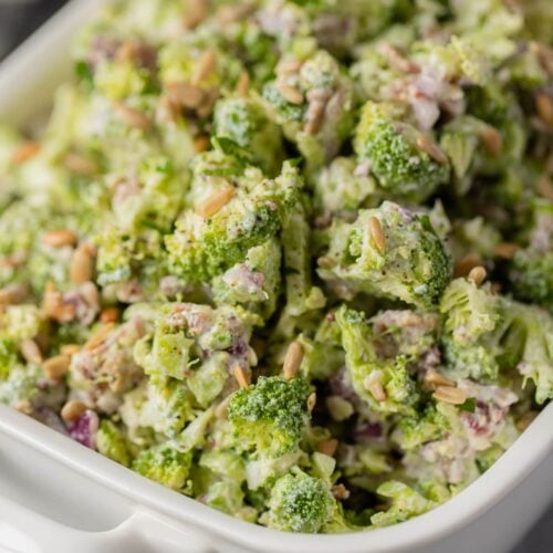 a white bowl of healthy broccoli salad on a grey background
