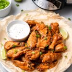 Crock Pot Chicken Wings on a platter with a slow cooker off to the side