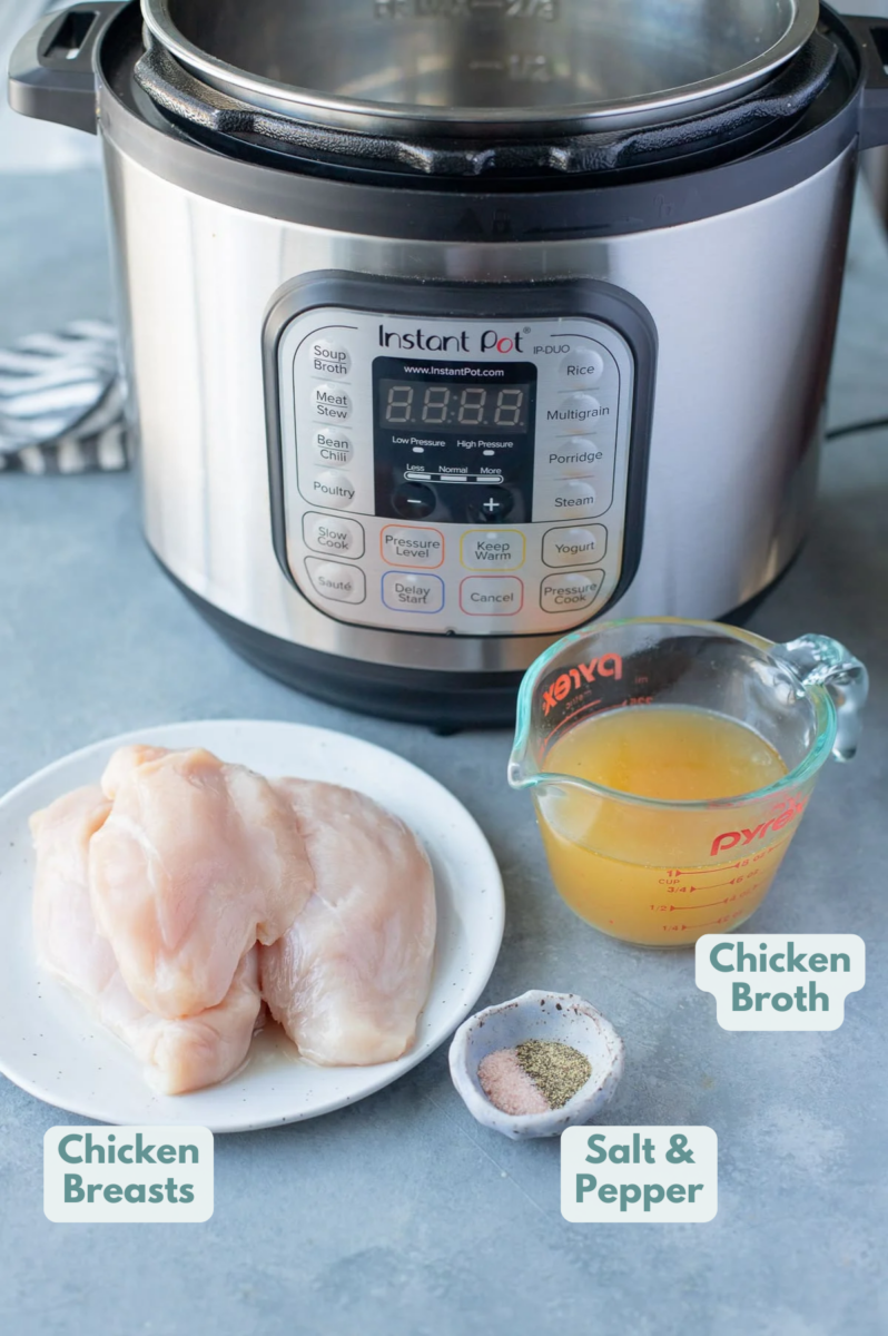 Ingredients for instant pot shredded chicken: a plate with chicken breasts, a cup with broth and salt/pepper