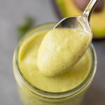 a close up of avocado ranch dressing in a mason jar