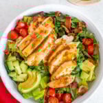 A close up of honey mustard dressing drizzled on a salad