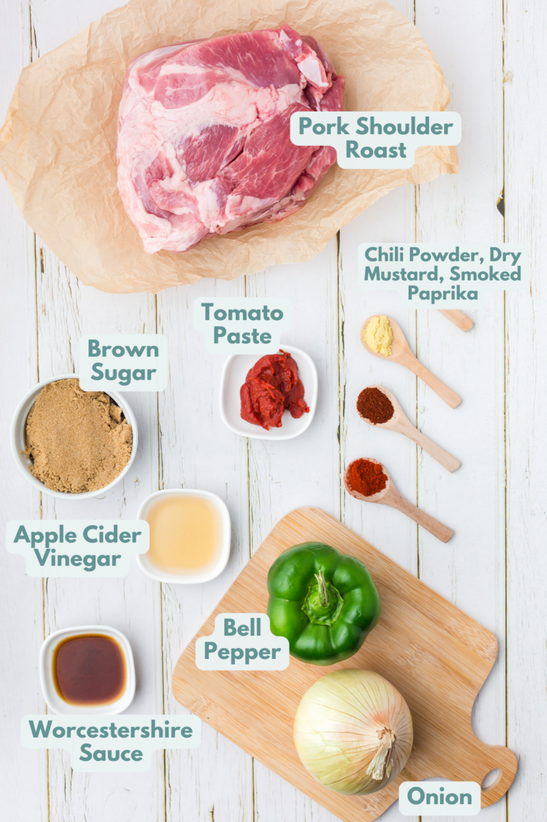 Ingredients for slow cooker pulled pork in white bowls: pork butt roast, onion, bell pepper, brown sugar, tomato paste, apple cider vinegar, chili powder, dry mustard, Worcestershire sauce, smoked paprika