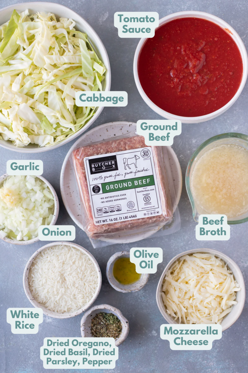 Ingredients for unstuffed cabbage bowls in white bowls: olive oil, ground beef, onion, garlic, pepper, oregano, basil, parsley, tomato sauce, white rice, beef broth, cabbage, mozzarella