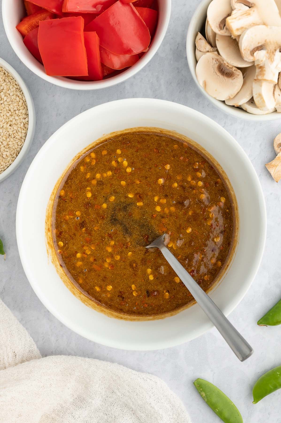Overhead view of stir fry sauce and a fork in a white bowl.