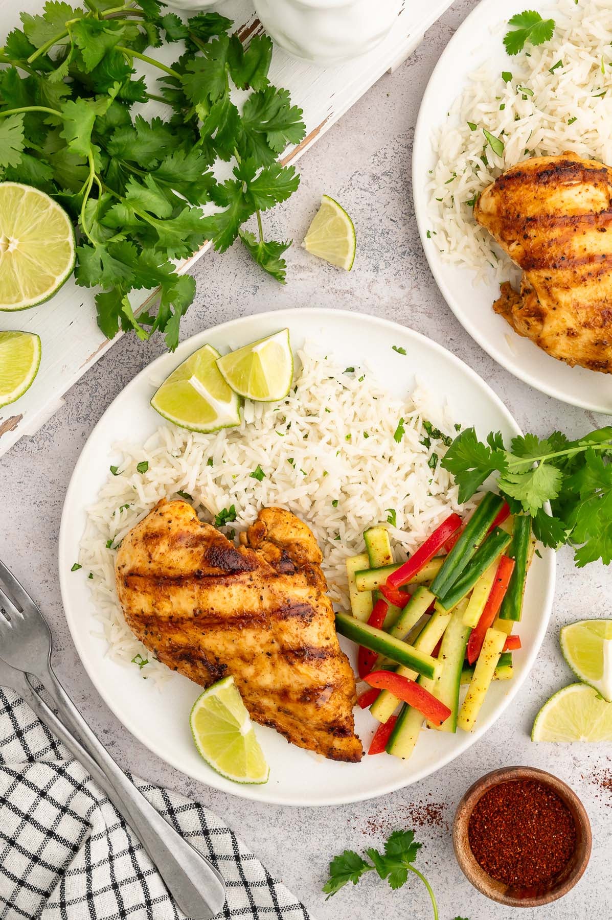 An overhead shot of a sliced Chili Lime Chicken Breast on a white plate with cilantro lime rice and pickled veggies on the side.