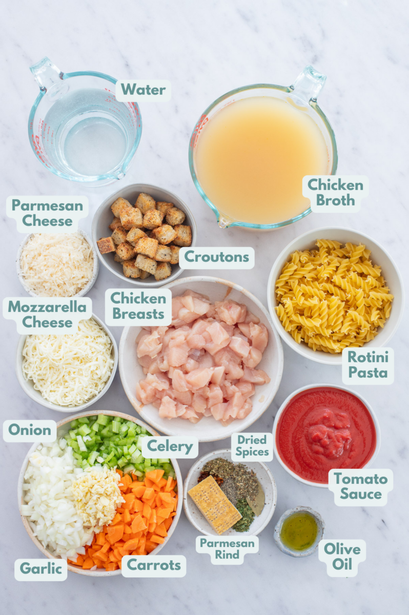 Labeled Chicken Parmesan Soup Ingredients in bowls and measuring cups on a counter.