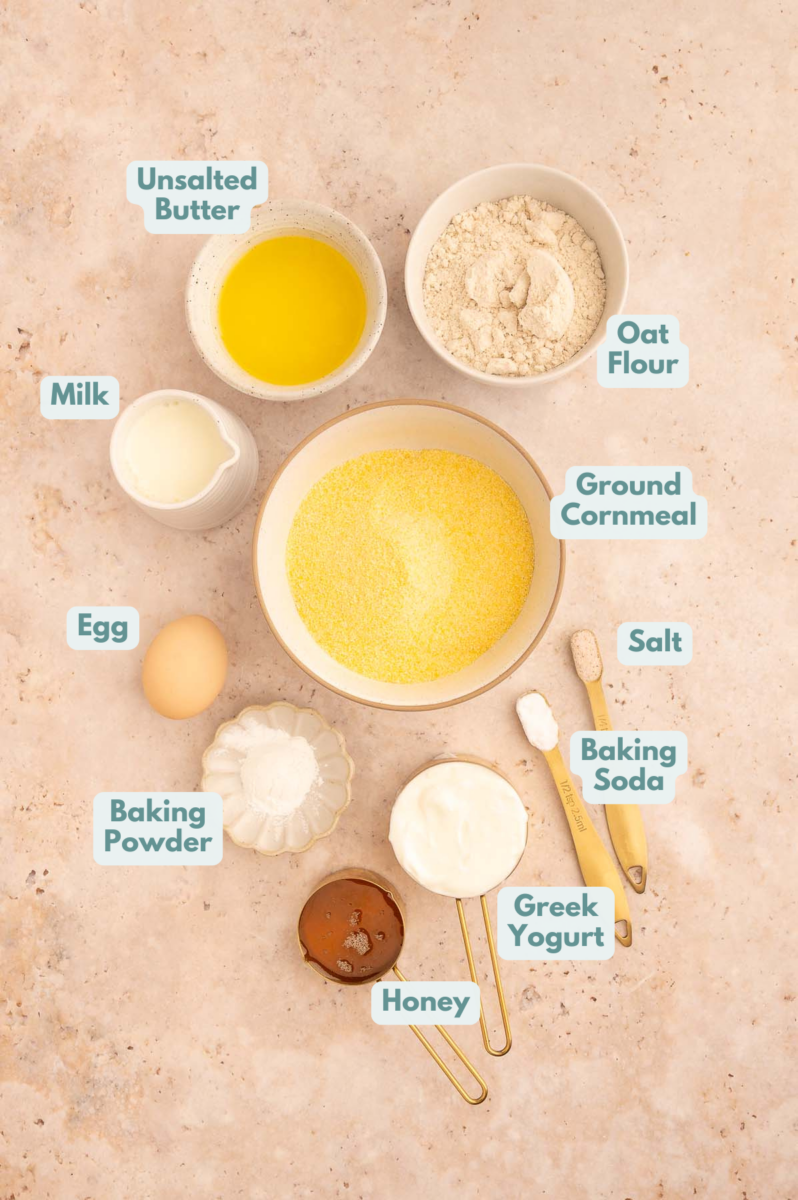 Labeled Healthy Cornbread Ingredients in bowls and measuring cups on a counter.