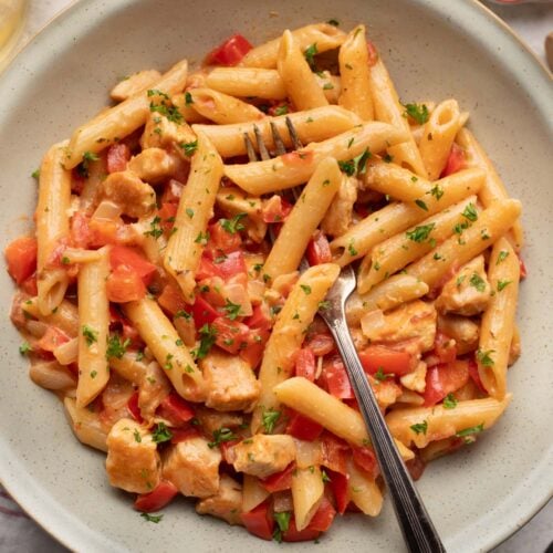 Cajun Chicken Pasta in shallow bowl with a fork in it.