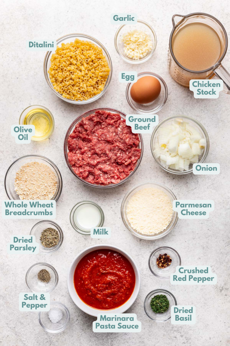 Labeled meatball pasta ingredients in bowls and measuring cups on a counter.