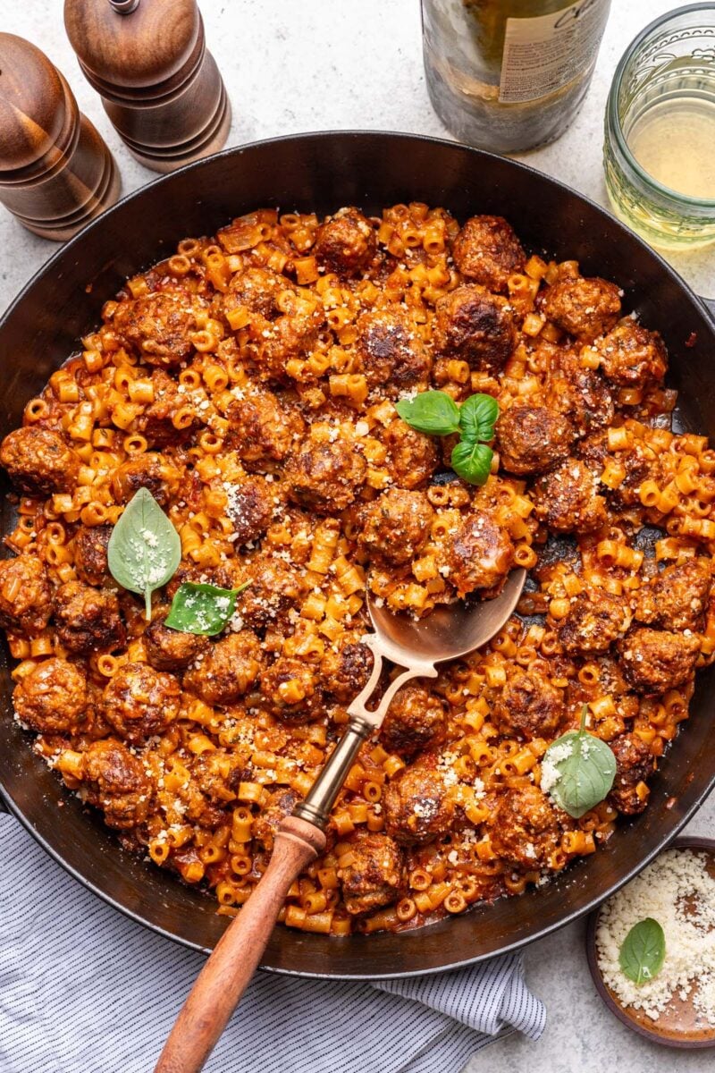 One pot meatball pasta in a cast iron skillet with a spoon in it. 