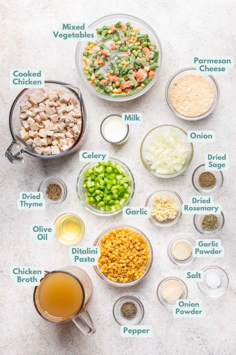 Labeled chicken pot pie pasta Ingredients in bowls and measuring cups on a counter.