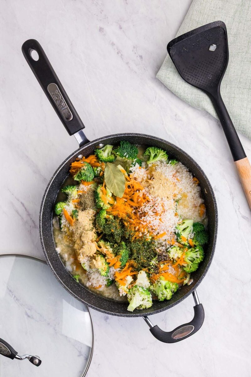 Ingredients for broccoli chicken rice in a skillet before being mixed together. 