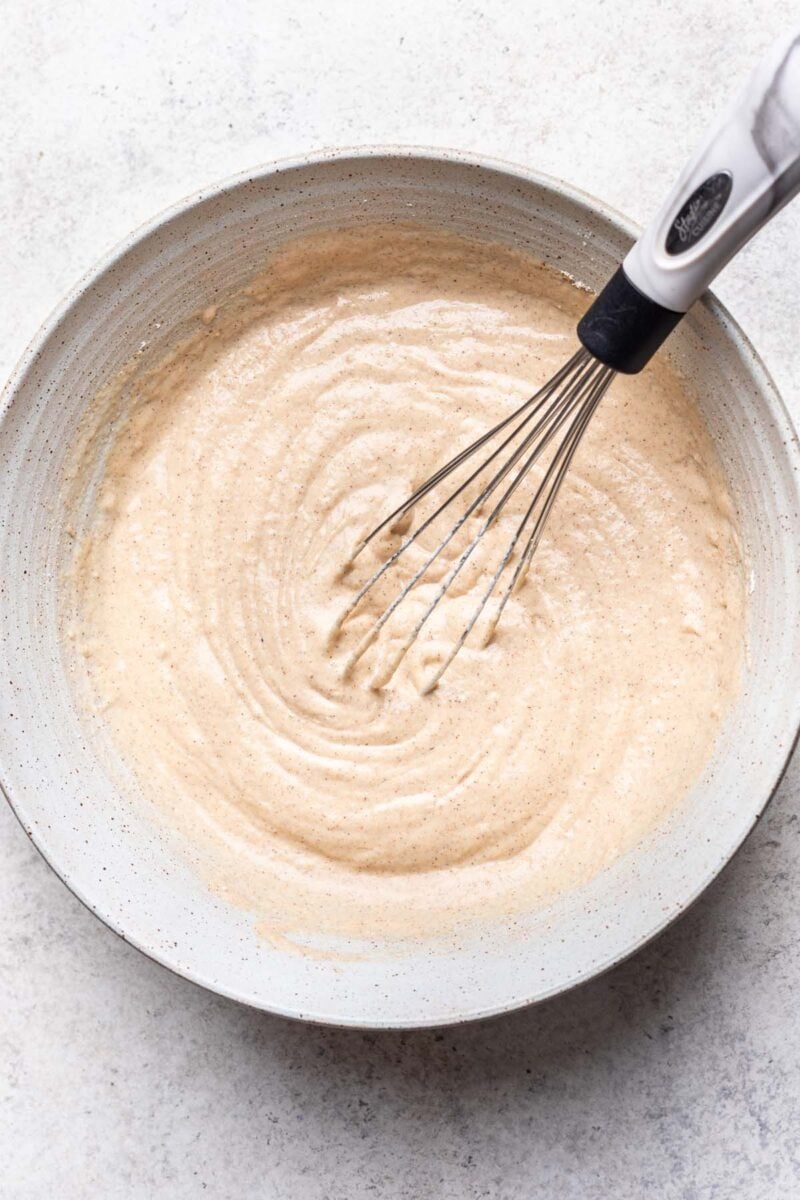 Oat flour pancake batter in a bowl being whisked together. 