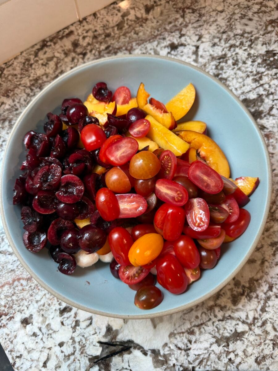 Peaches, cherries and tomatoes in a blue bowl
