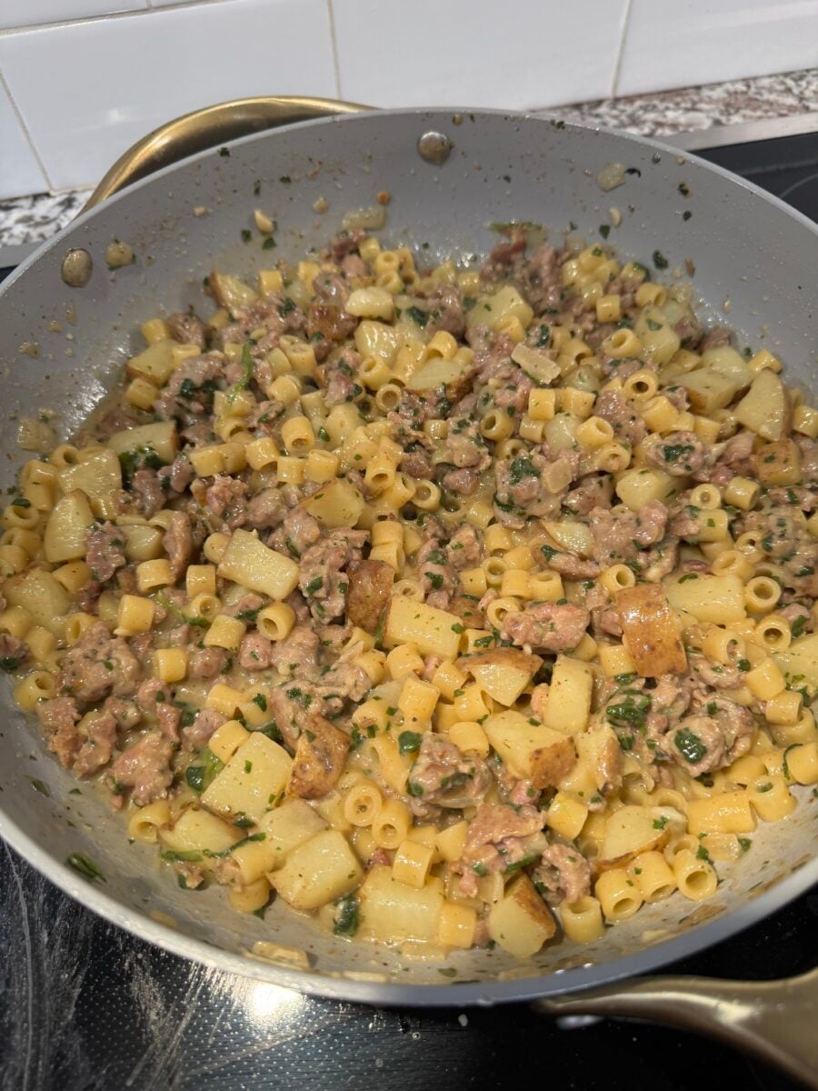 A close up of zuppa toscana pasta in a grey skillet
